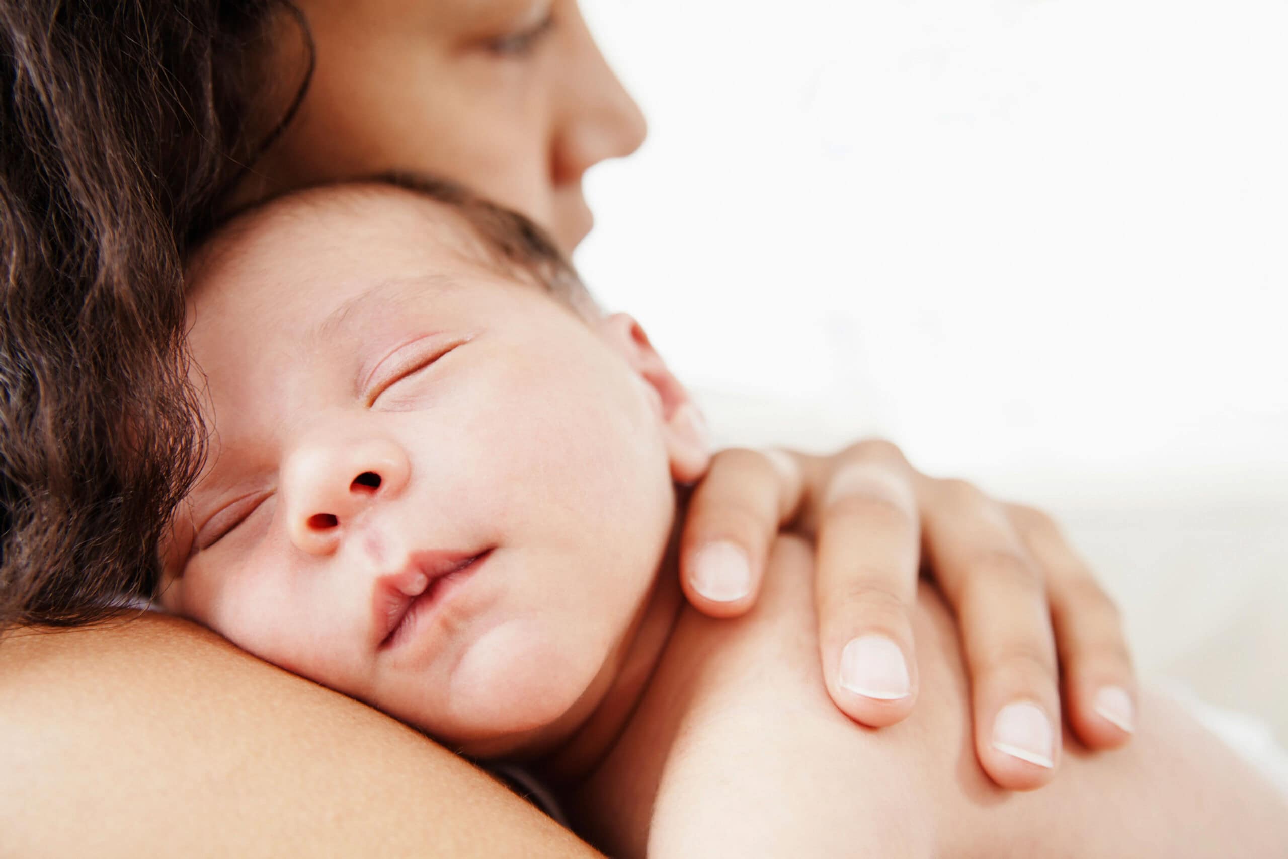 Baby sleeping on mothers shoulder