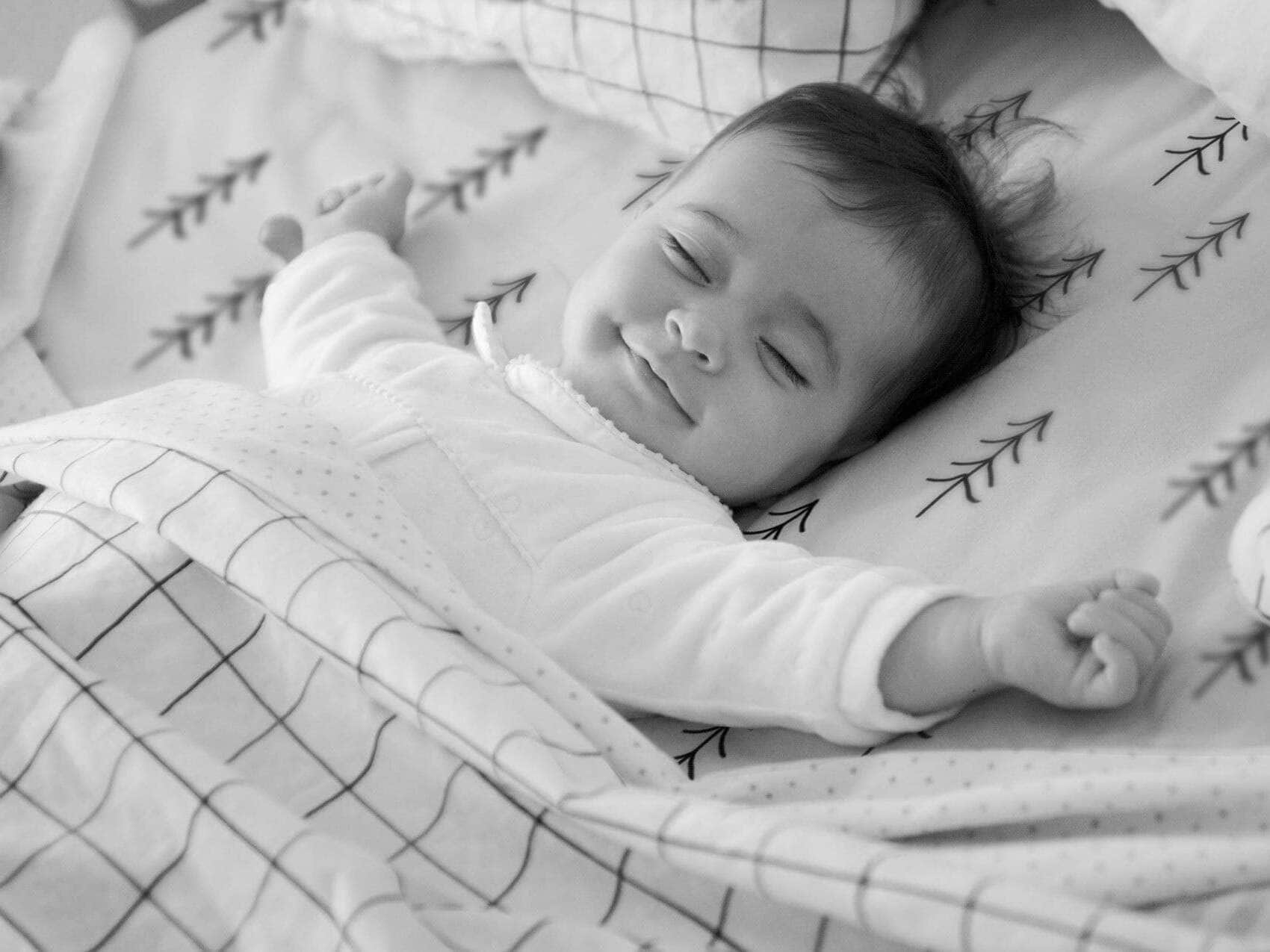Smiling baby sleeping mono