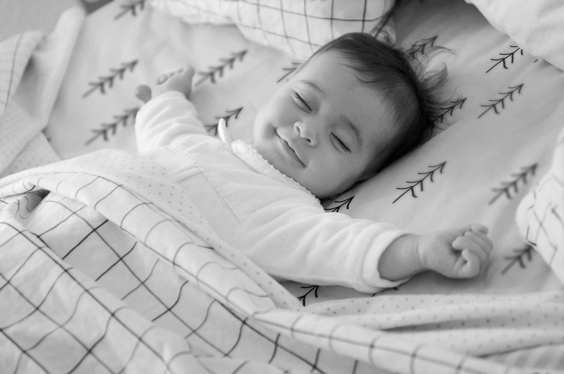 Smiling baby sleeping mono